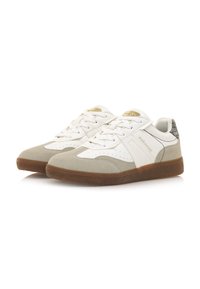 Zapatillas blancas y grises con un upper de ante y cuero, que cuentan con detalles perforados, un collar acolchado y una suela de goma marrón.
