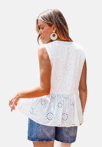 Witte, mouwloze top met bloemenborduursel, gerimpelde zoom en een losse pasvorm, in combinatie met denim shorts. Gelaagde stof met een ademend ontwerp.