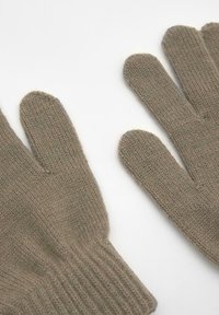Pletenice rukavice svijetle taupe boje, s rebrastim završetkom, mekim tekstilom i dizajnom s pet prstiju koji omogućuje spretnost.