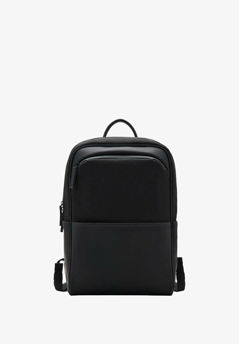 Mochila negra con una textura suave, un asa superior, correas de hombro ajustables y un bolsillo delantero con cremallera. Diseño minimalista.