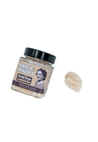 Barattolo di scrub per il corpo con un coperchio nero, dotato di un'etichetta con un'immagine, colori marroni e beige, e un pezzo di sale marino grosso accanto ad esso.