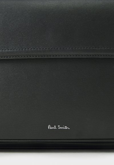 Black leather clutch with a smooth texture, featuring precise stitching and a white 'Paul Smith' logo on the bottom right corner.
