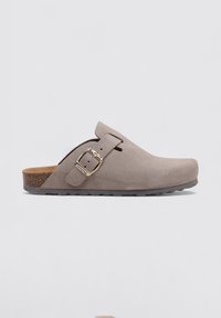 Gray suede clogs featuring a rounded toe, adjustable buckle, and cork footbed. Rubber sole with a textured tread for grip.