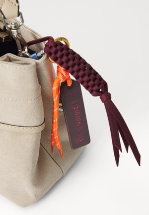 Beige Stofftasche mit Öffnung an der Oberseite, ausgestattet mit einem kastanienbraunen geflochtenen Akzent, orange-weißer Schnur und einem Schild, auf dem in Rot "Hallo Sommer!" steht.