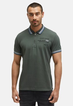 Dunkelgrünes Poloshirt mit einem Reißverschlusskragen, ausgestattet mit blau gestreiften Akzenten am Kragen und an den Ärmeln sowie bedrucktem Text auf der Brust.