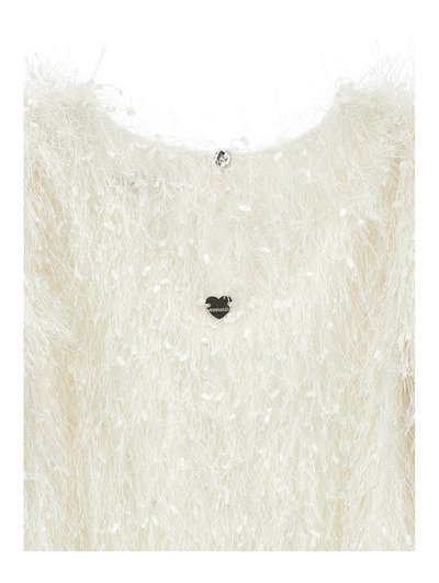 Pull blanc duveteux avec une surface texturée et fluffy. Présente un petit charme en forme de cœur argenté au dos du col et un bouton décoratif.