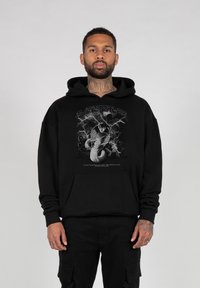 Felpa nera con cappuccio in cotone con una grafica di un serpente e un fulmine. Include una tasca frontale ampia e polsini a costine.