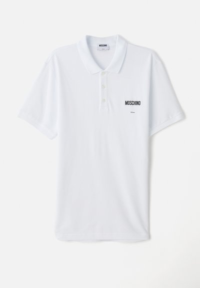 Valkoinen polo-paita, joka on valmistettu puuvillasta. Paitassa on kolmipainikehakemus, lyhyet hihat ja pieni musta "Moschino"-logo rinnassa.