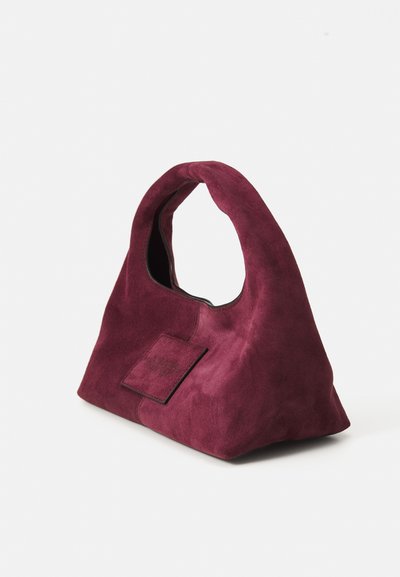 Burgundy mokka käsilaukku, jossa on kaareva kahva, kolmiomainen muoto ja etupussi. Suora pinta ja minimalistinen design.