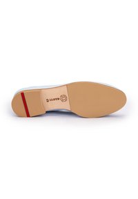Semelle en cuir avec une finition lisse couleur fauve, présentant un accent rouge et un marquage en relief. Bout arrondi et dessous légèrement texturé pour une meilleure adhérence.