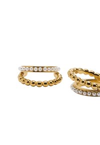 Trzy pierścionki do zestawiania, wykonane ze złotego metalu. Jeden pierścionek ma rząd małych białych pereł, inny charakteryzuje się koralikowym wzorem. Gładkie powierzchnie.