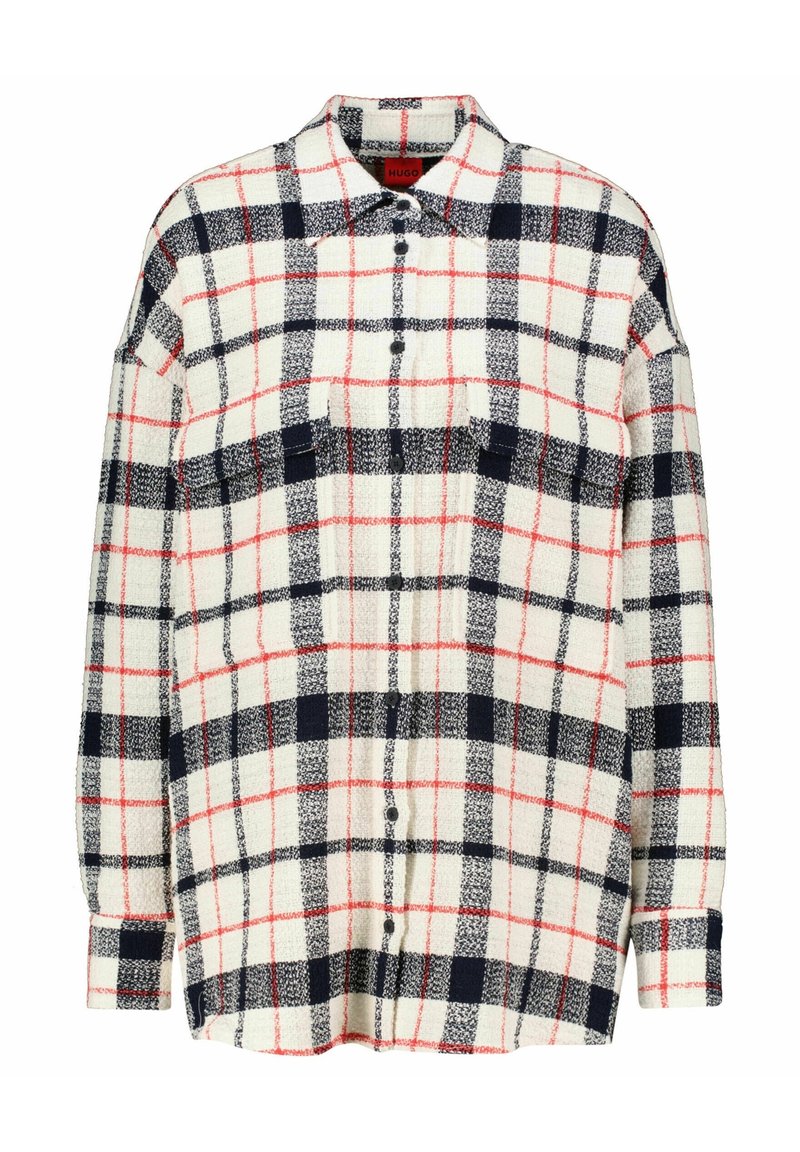 Flanellen shirt met een crèmekleurige basis, marineblauw en rood geruit patroon. Voorzien van knoopsluiting, lange mouwen en twee borstzakken.