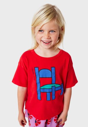 Rotes Baumwoll-T-Shirt mit einem grafischen Design eines blauen Stuhls und eines grünen Tisches. Das Shirt hat kurze Ärmel und einen lässigen Schnitt.