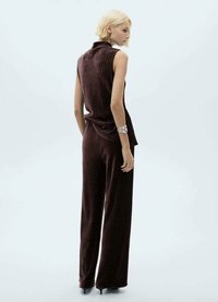 Bordeaux tweed twee-delige outfit met een mouwloos topje met hoge kraag en wijde broekspijpen, gemaakt van gestructureerde stof.