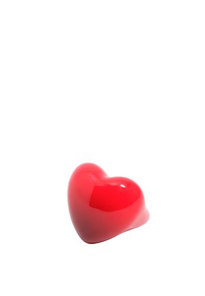 Lesklý červený objekt v tvare srdca s hladkým povrchom, izolovaný na bielom pozadí.