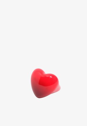 Läikiv punane südamekujuline ese, mille pind on sile, valgel taustal isoleeritud.