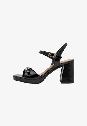 Sandales à talons en cuir verni noir avec un large talon carré, design à bout ouvert, bride à la cheville et détails avec boucle. Texture lisse sur toute la surface.