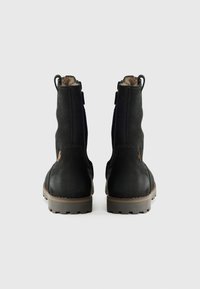 Bottines en cuir noir avec une finition texturée, dotées de petites anses sur les côtés et d'une semelle en caoutchouc robuste. Vue arrière avec des détails cousus.