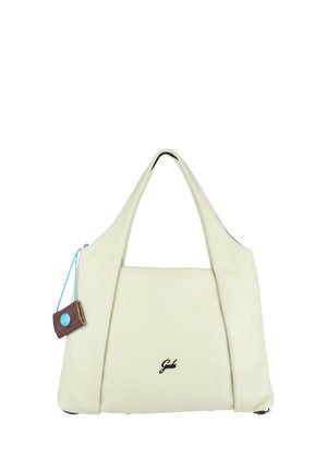 Borsa color crema con due manici, una piccola etichetta marrone attaccata con un filo blu e un logo nero "Gabs" sul davanti.