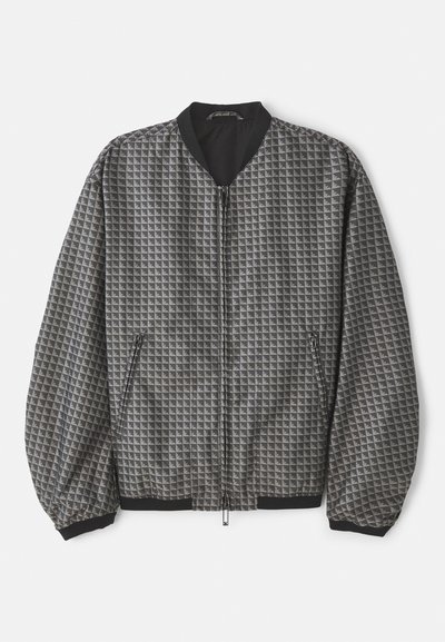 Harjattu pommittaja takki harmaana geometrisella kuviolla. Varustettu vetoketjulla, mustalla kauluksella sekä joustavat hihansuut ja helma.