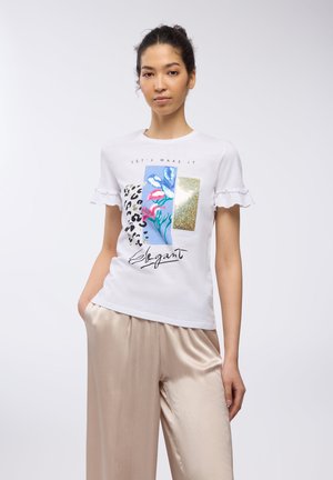 T-shirt bianco a maniche corte con bordi arricciati, caratterizzato da un design grafico che include stampa leopardata, elementi floreali e accenti dorati.