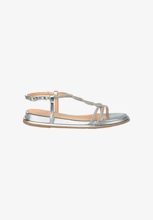 Silver flat sandal with a T-strap design, braided detail, and a rounded toe. Features an adjustable ankle strap and flat sole.