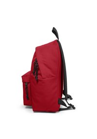 Le sac à dos en tissu rouge présente un design structuré, des bretelles noires ajustables, une poche avant avec fermeture éclair et un matériau texturé.