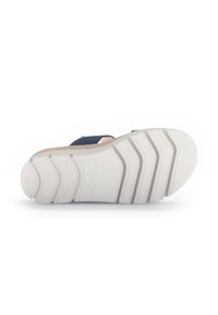 Footwear featuring a white rubber sole with textured patterns, a navy upper, and a cork accent on the midsole. No visible branding.