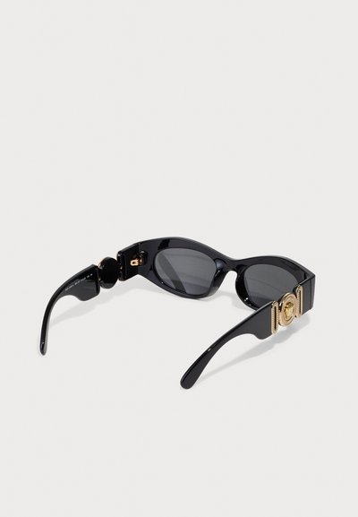 Lunettes de soleil noires au design élégant, verres sombres, accent de matériel en or sur le côté et finition brillante.