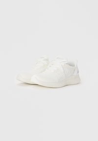 Baskets de sport blanches avec un dessus en tissu tricoté, fermeture à lacets et semelle texturée. Design minimaliste avec des accents de marque en argent.