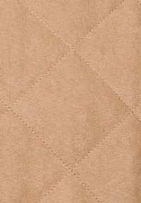 Beige gestepptes Gewebe mit Rautenmuster, weicher Textur und feinen Nähakzenten, die ein glattes und einheitliches Erscheinungsbild schaffen.