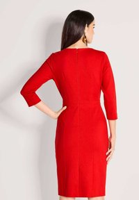 Rotes, figurbetontes Kleid mit dreiviertellangen Ärmeln, Reißverschluss am Rücken und mittellanger Länge bis zur Wade. Glatter Stoff mit dezenten Nahtdetails.