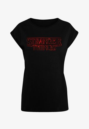 Zwarte T-shirt met korte mouwen en ronde hals, met "STRANGER THINGS" in vetrode hoofdletters op de voorkant. Zachte stof.