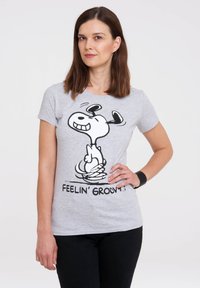 T-shirt en coton gris avec un graphique de dessin animé en noir et blanc d'un chien, avec le texte "FEELIN' GROOVY!" imprimé en dessous.