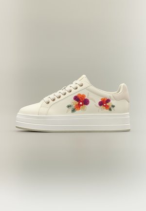 Witte platformsneaker met bloemrijke borduursels in oranje, paars en groen aan de zijkant en witte veters.