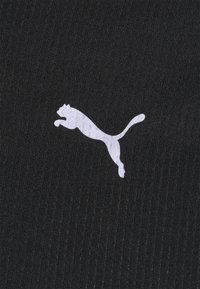 Černá textilie s vertikálním žebrováním, na které je bílé logo Puma v designu skákajícího kočky. Materiál vypadá hladce a má konzistentní texturu.