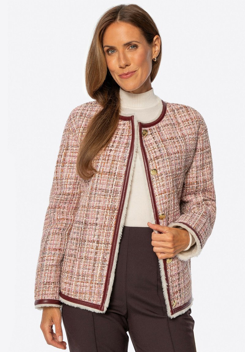 Strukturalna różowa i kremowa kurtka w plecionkę z okrągłym dekoltem, złotymi guzikami i bordowym wykończeniem. Posiada miękką podszewkę i prosty krój.