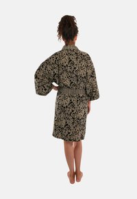 Zwart kimono-stijl badjas met gouden rozenpatroon, brede mouwen en elastische taille. Zachte stof met een middellange snit.