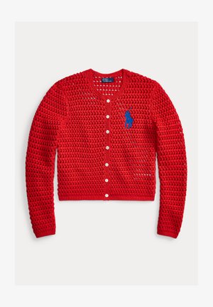 Punainen virkattu neuletakki, jossa pitkät hihat, valkoiset napit edessä ja sininen brodeerattu Polo Ralph Lauren -logo vasemmalla rinnuksella.