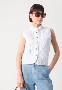 Colete sem mangas acolchoado com um padrão listrado em branco e azul claro, apresentando botões dourados e dois bolsos frontais.