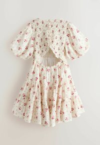 Krémové šaty s ružovým kvetinovým vzorom, nafúknutými rukávmi, elastickým pásom, tylovou zadnou časťou a otvoreným výstrihom na chrbte s volánikovou lemovkou.