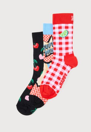 Tri šarene čarape s različitim uzorcima: crvena karirana s kriškom limete, narančasta s točkicama i stripovskim tekstom te crna s trešnjama.