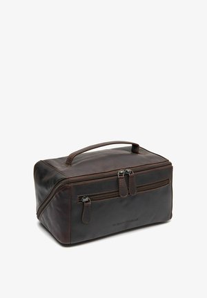 Trousse de toilette en cuir brun avec une forme rectangulaire, fermetures zippées, une poignée supérieure et une surface texturée. Couture notable sur les coutures.