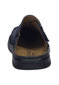 Bakvy av en marinblå läder slip-on sko med en texturerad yta, beige inredning och svart gummisula. Justerbart remdetalj synligt.