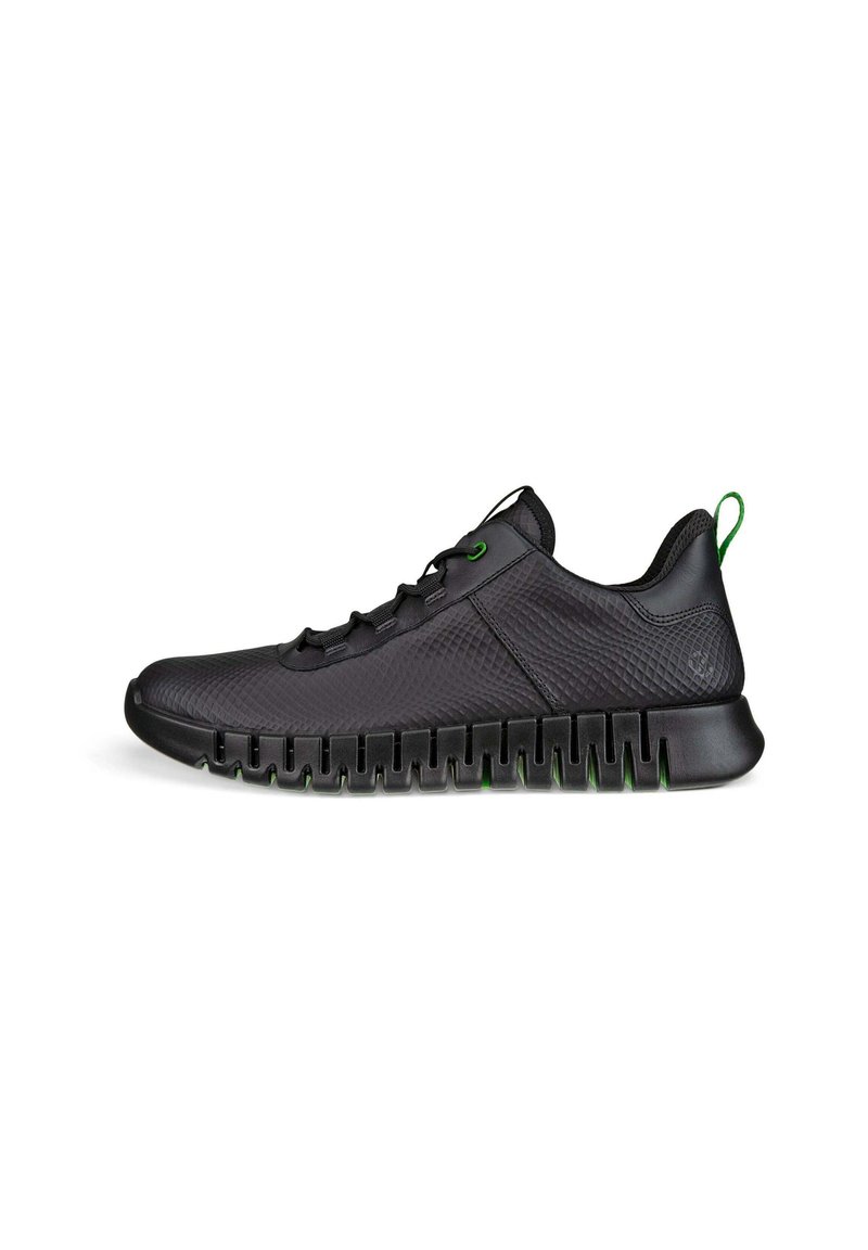 Black athletic shoes with a textured upper, green accents on laces and heel tab, and a ridged black sole for traction.