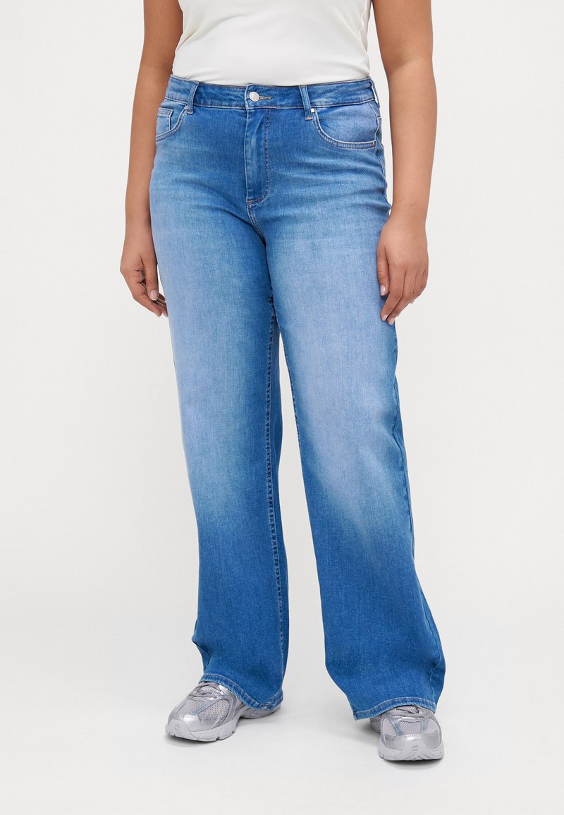 Light blue, wide-leg jeans made of denim with a faded finish. Features belt loops, front pockets, and a zipper fly.