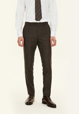 Grau maßgeschneiderte Hose aus einem strukturierten Stoff, mit einem schlanken Schnitt und flachem Vorderteil, kombiniert mit polierten braunen Dressschuhen.