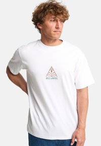 Short-sleeve, crew neck white t-shirt featuring a printed brown and teal geometric logo on the front, made of soft cotton fabric.