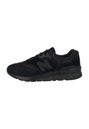 Zwarte New Balance atletische sneaker met mesh en suède bovenwerk, vetersluiting en een gedempte zool zichtbaar vanuit zijaanzicht.
