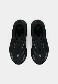 Mustad spordijalatsid võrgust ja sünteetilisest pealsest, tekstuurse taldaga ja lamedate paeltega. Omavad helkivat logo ja nurgelisi disainielemente.